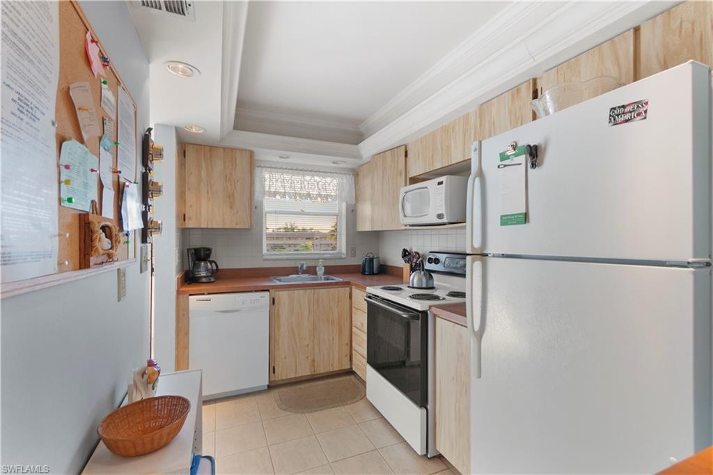 499 Forest Lakes Boulevard, Unit 2304 Naples, FL 34105 - Photo 9 of 21 a kitchen with stainless steel appliances a refrigerator sink and cabinets
