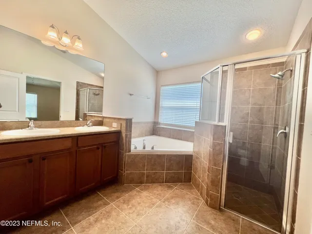 a bathroom with a tub a sink and a mirror