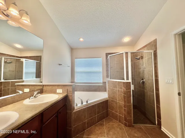 a bathroom with a granite countertop sink a mirror and a bathtub