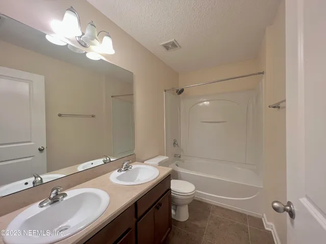 a bathroom with a sink double vanity granite tub and a mirror