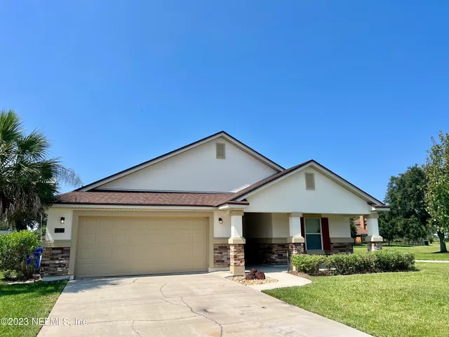a front view of a house with a yard and trees