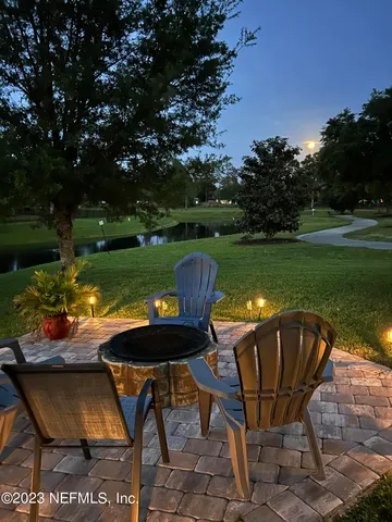 a view of a swimming pool and lounge chairs in back yard