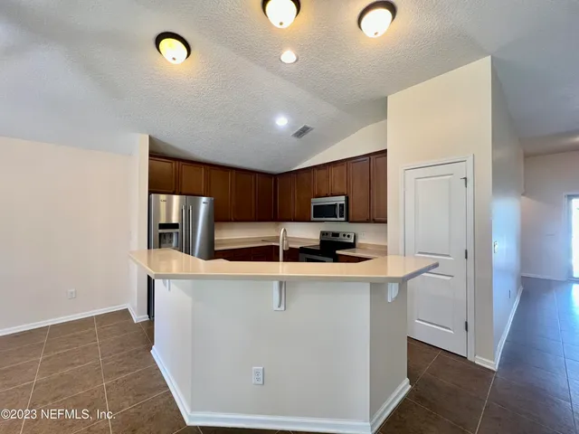 a kitchen with stainless steel appliances a sink and a refrigerator