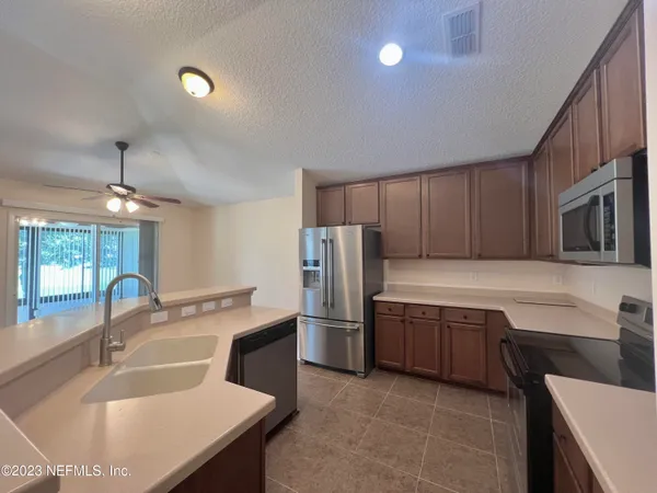 a kitchen with stainless steel appliances granite countertop a sink refrigerator and microwave