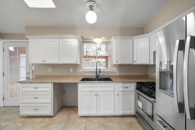 a kitchen with granite countertop a sink stainless steel appliances and cabinets