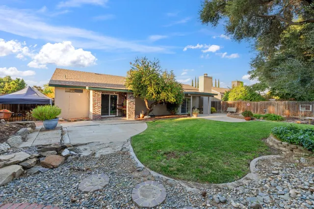a view of a big house with a big yard and potted plants