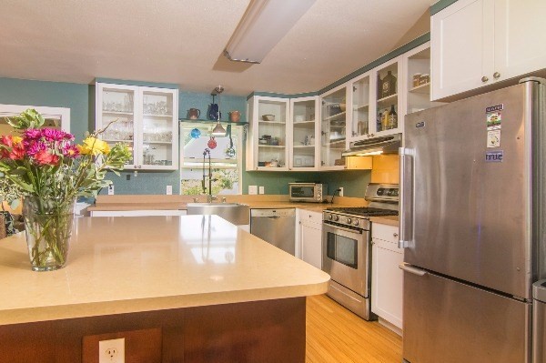 418 Puuopae Road, Unit A Kapaa, HI 96746 - Photo 13 of 25 a kitchen with a refrigerator and a white cabinets