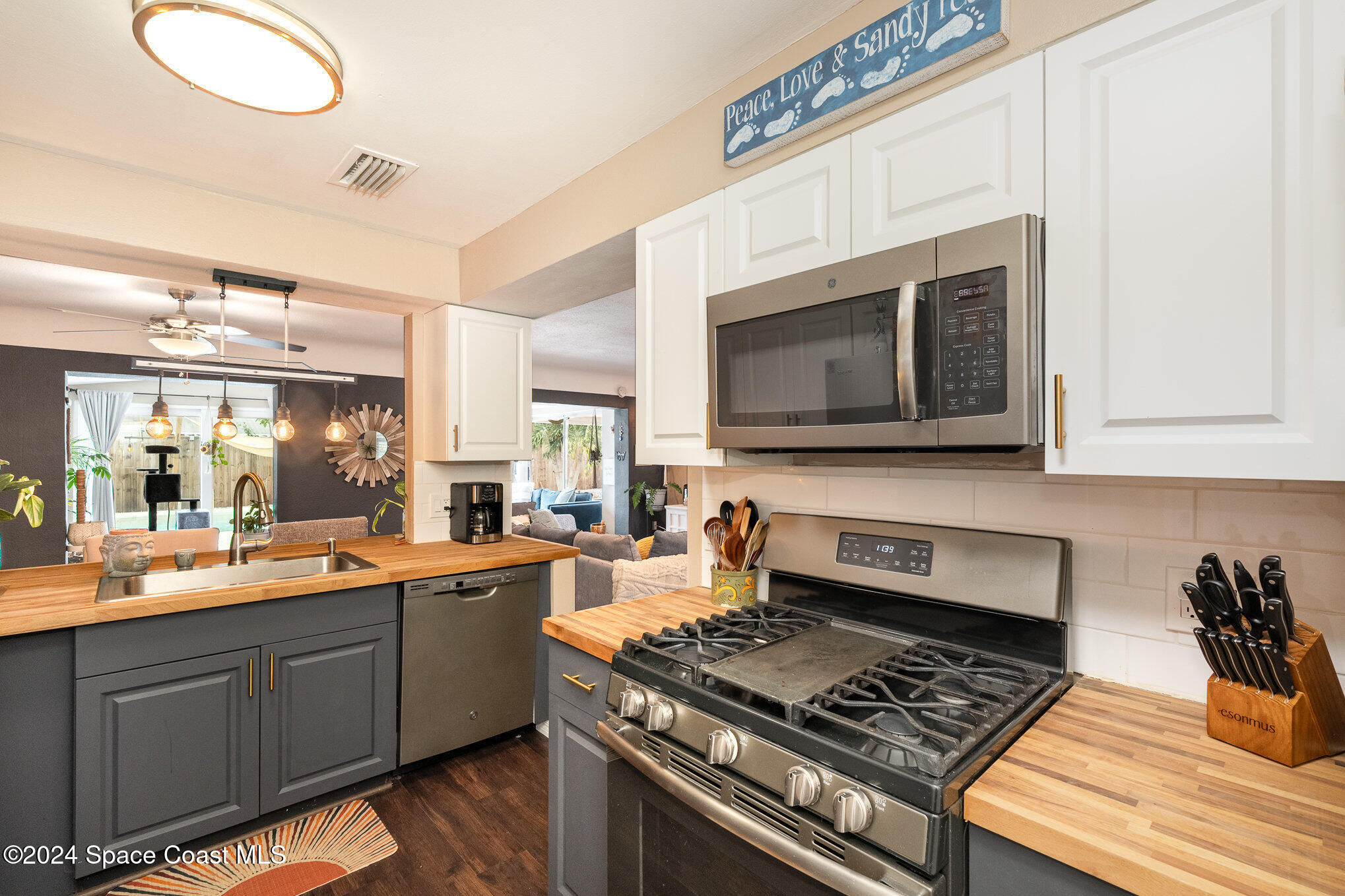 a kitchen with stainless steel appliances a stove a sink and a microwave