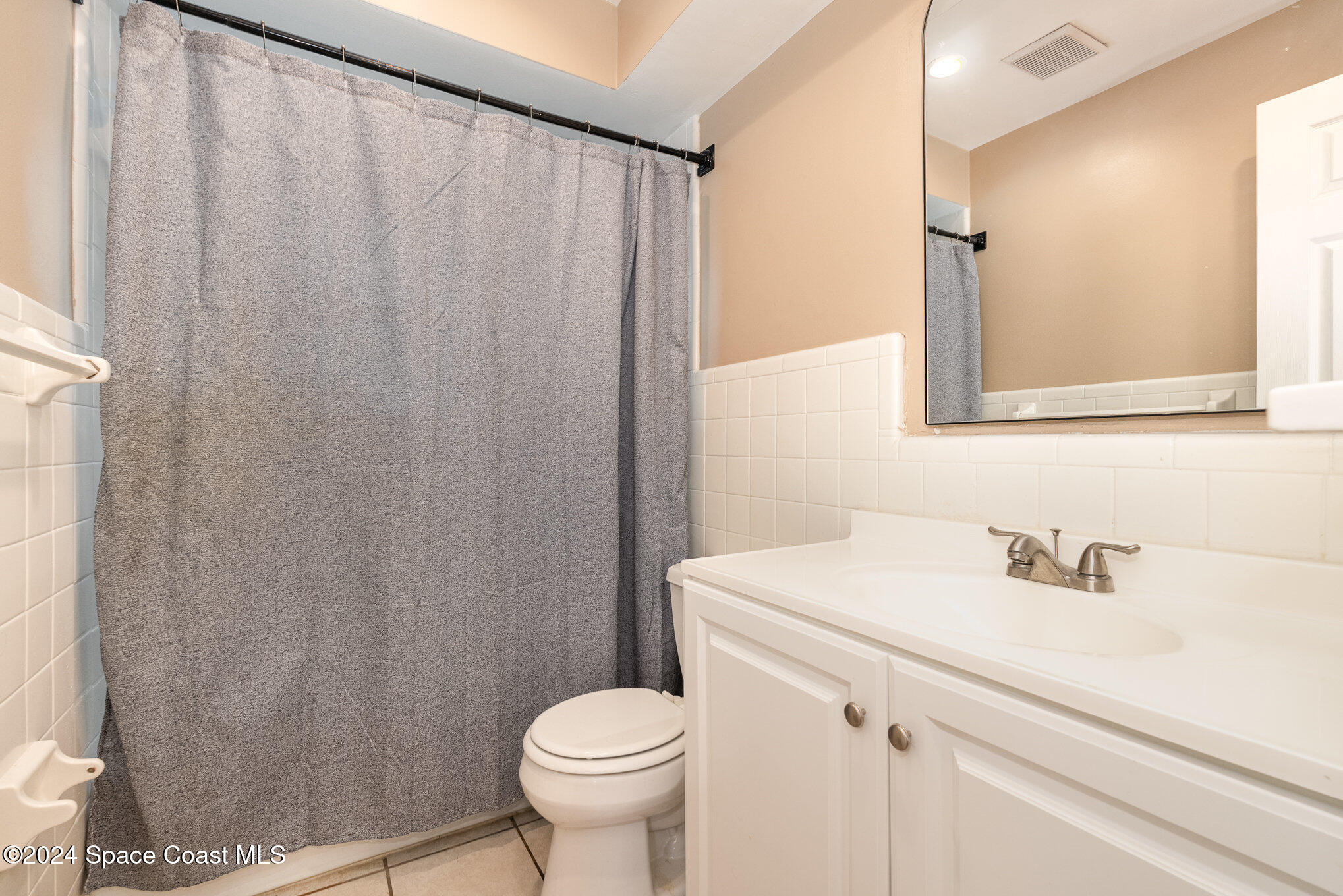 800 1st Street Merritt Island, FL 32953 - Photo 11 of 28 a bathroom with a sink a toilet and shower curtain