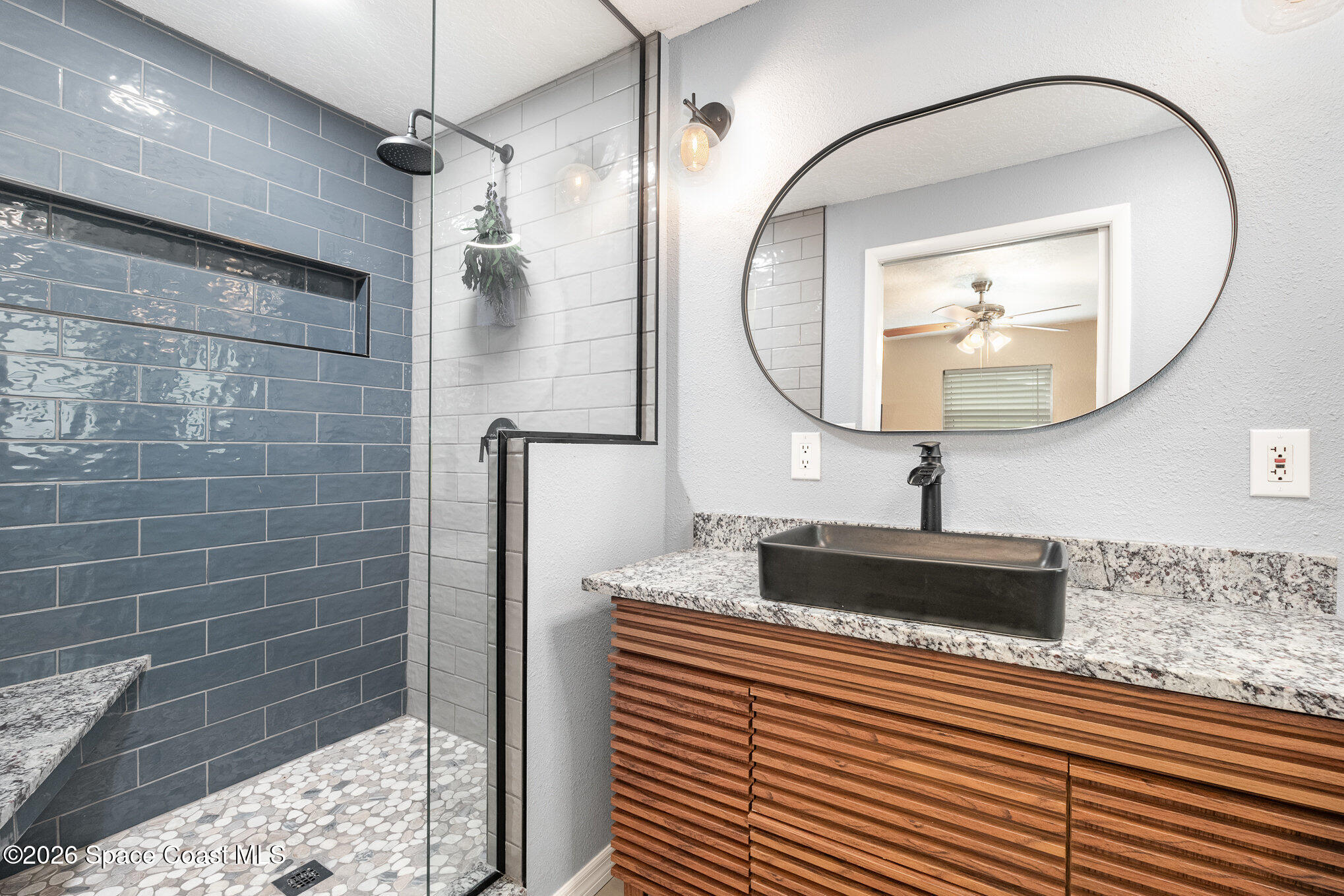 800 1st Street Merritt Island, FL 32953 - Photo 15 of 28 a bathroom with a sink a glass door and a mirror