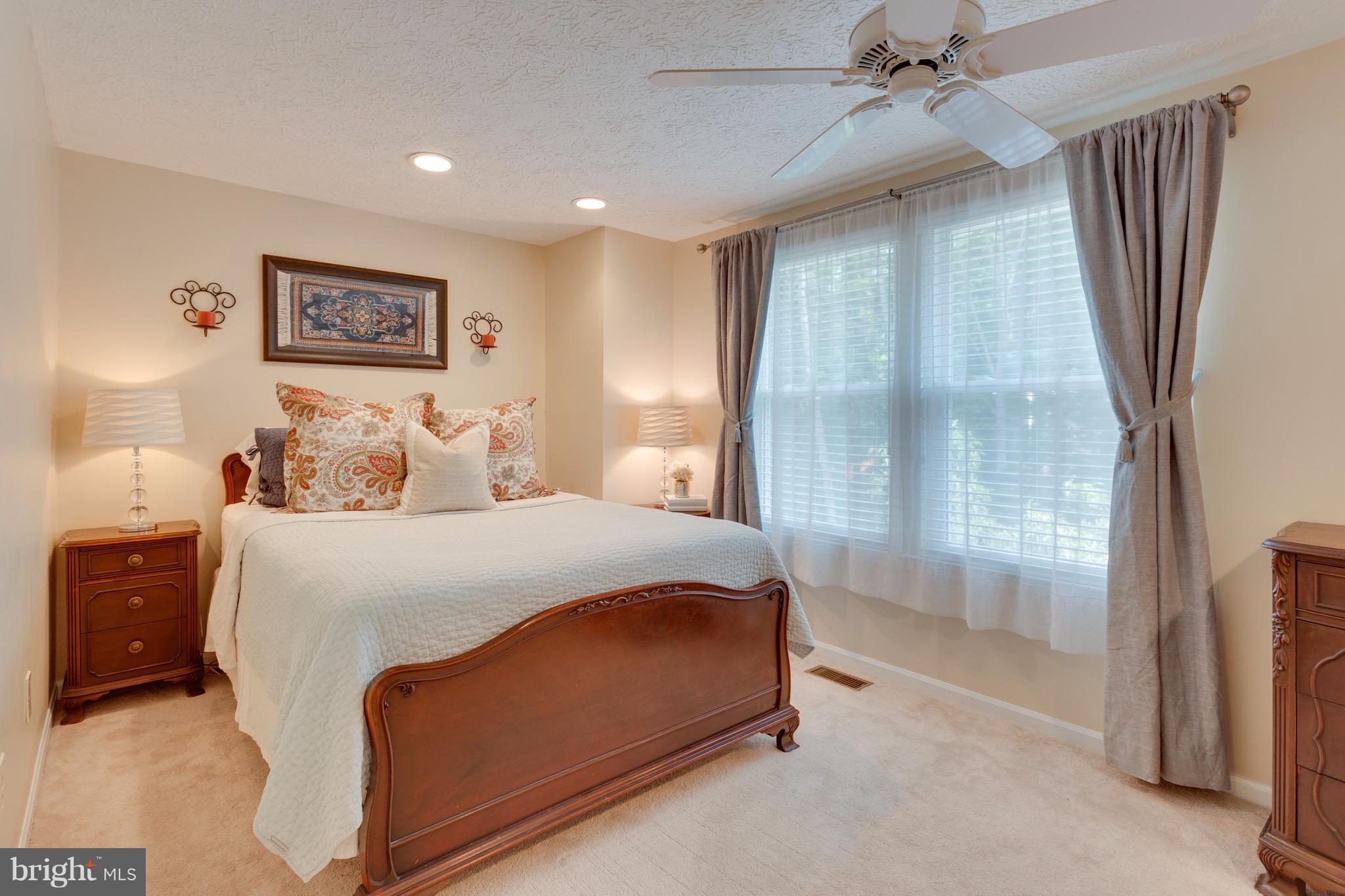 6571 Forest Dew Court Springfield, VA 22152 - Photo 11 of 20 a bedroom with a large bed and a chandelier