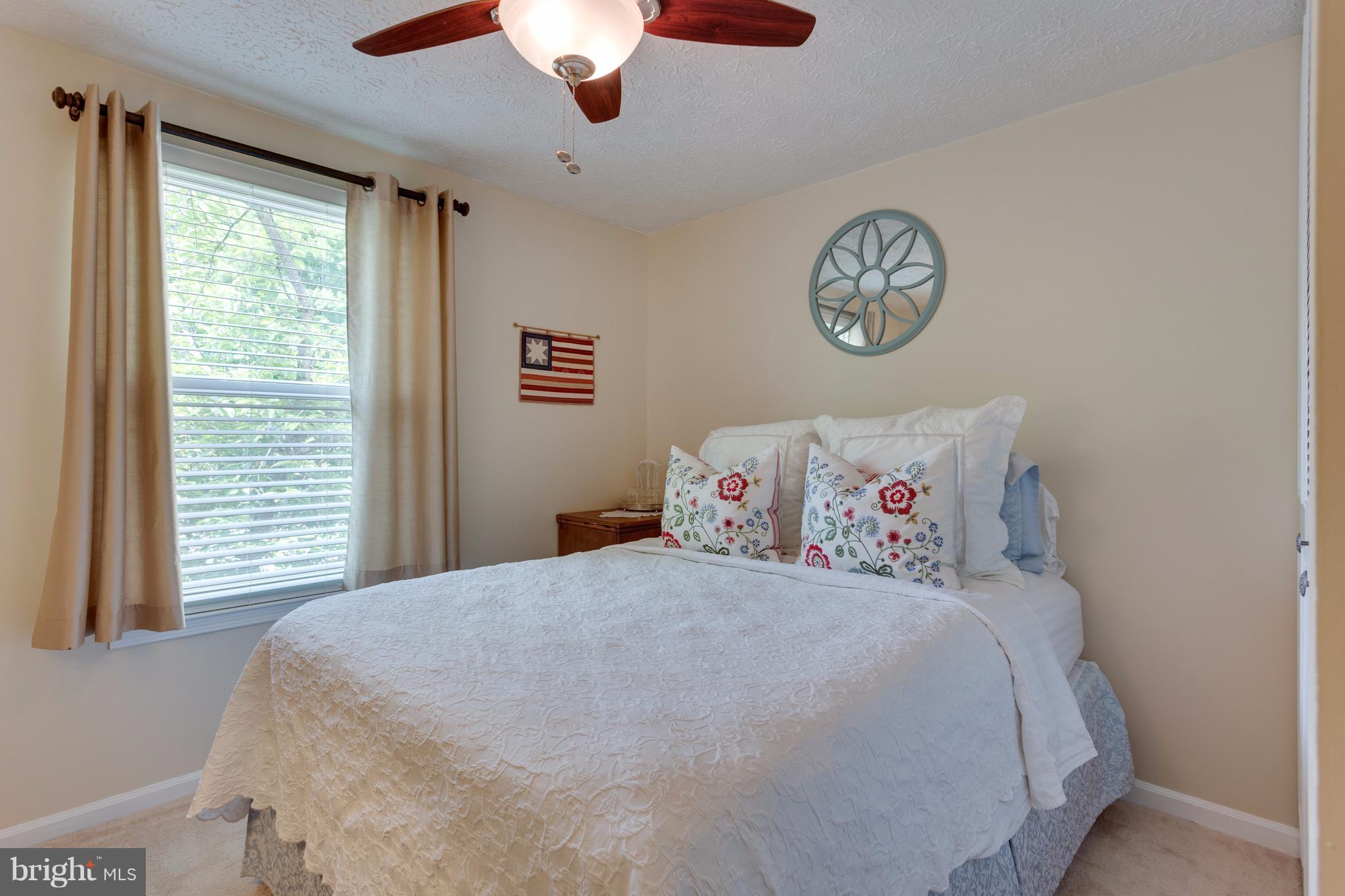 6571 Forest Dew Court Springfield, VA 22152 - Photo 12 of 20 a bedroom with a bed and a chandelier