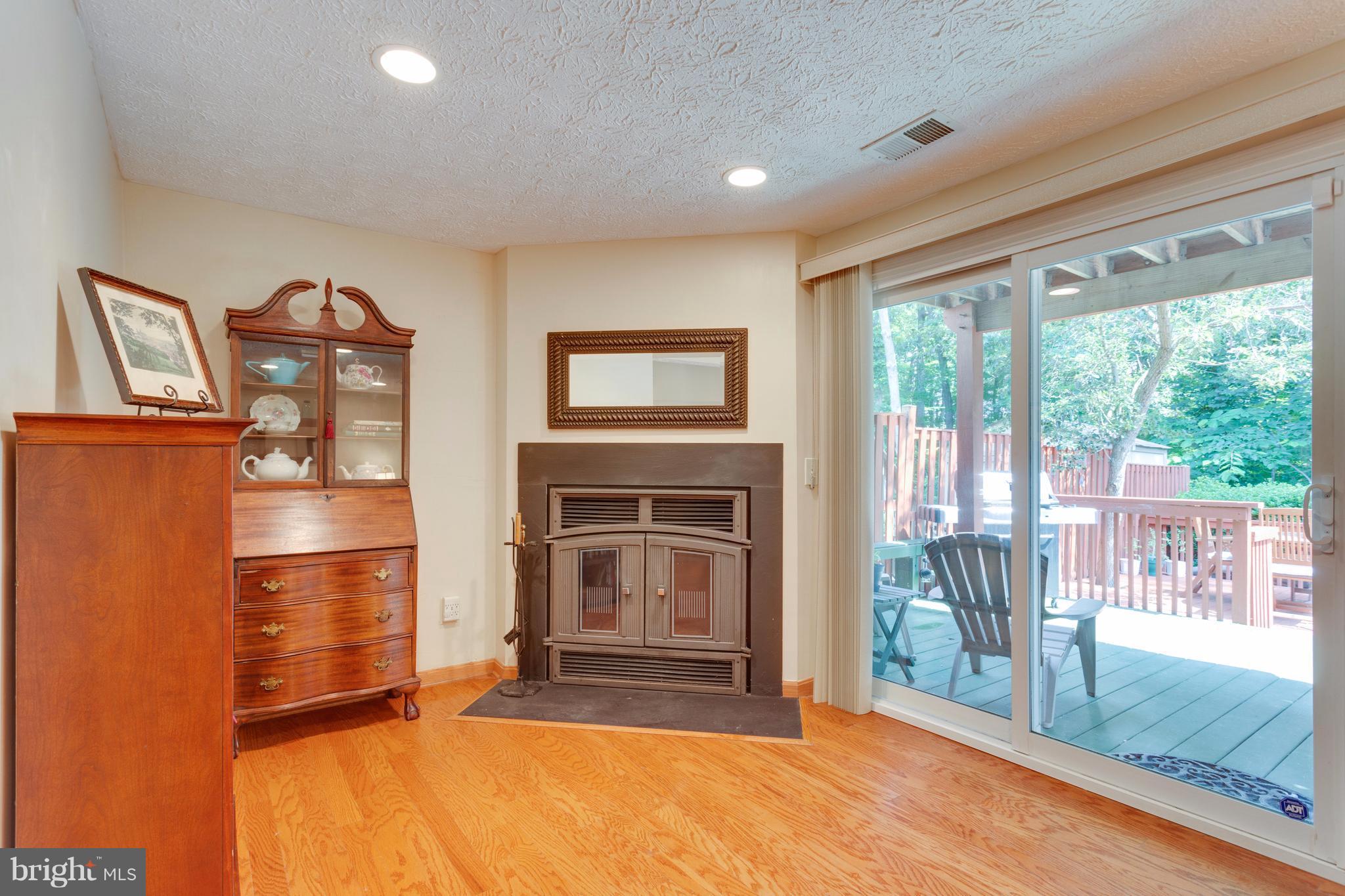 6571 Forest Dew Court Springfield, VA 22152 - Photo 14 of 20 a living room with furniture a fireplace and a floor to ceiling window