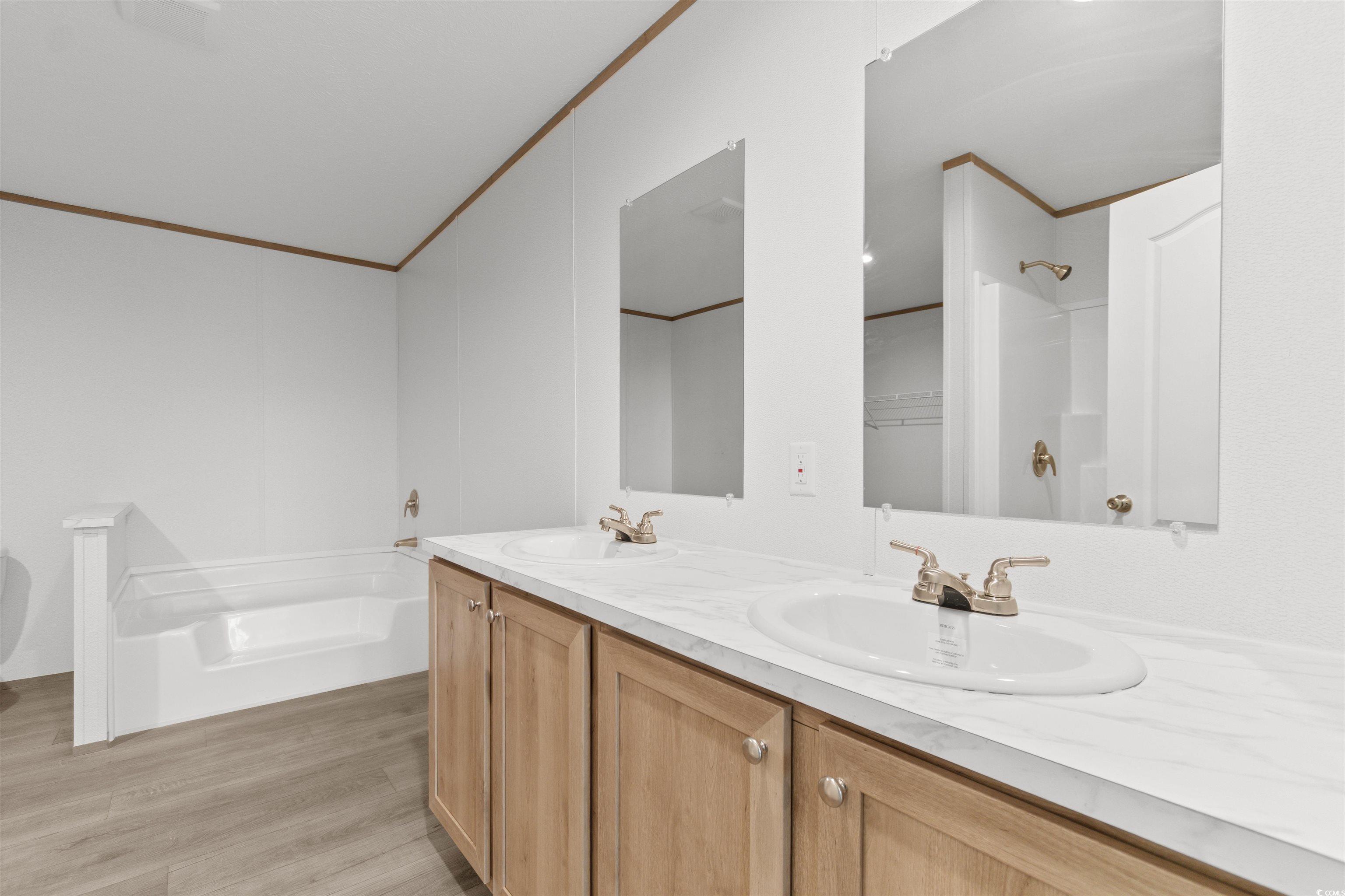 6613 Strickland Road Green Sea, SC 29545 - Photo 15 of 38 Full bath with a bath, double vanity, light wood-style flooring, ornamental molding, and a shower