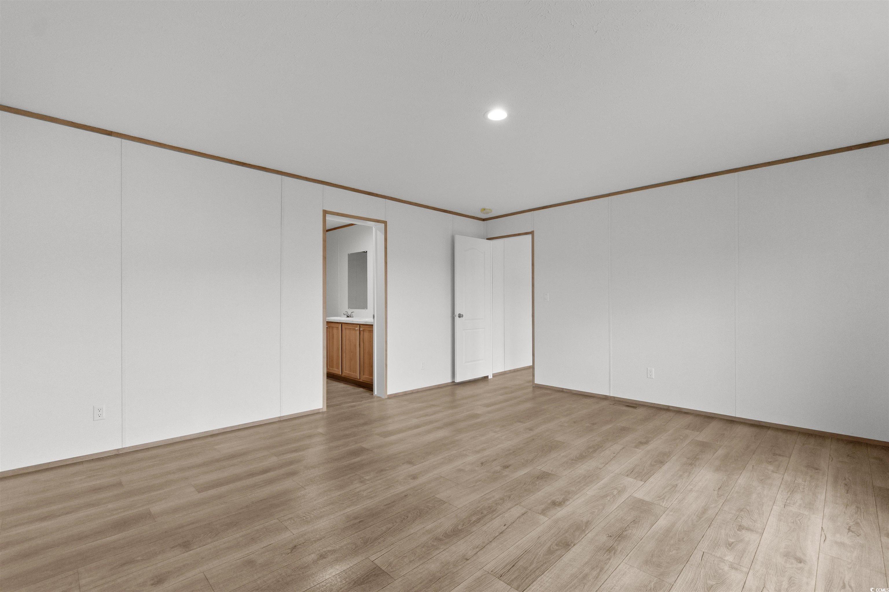 6613 Strickland Road Green Sea, SC 29545 - Photo 18 of 38 Unfurnished room with light wood-style flooring, ornamental molding, and recessed lighting