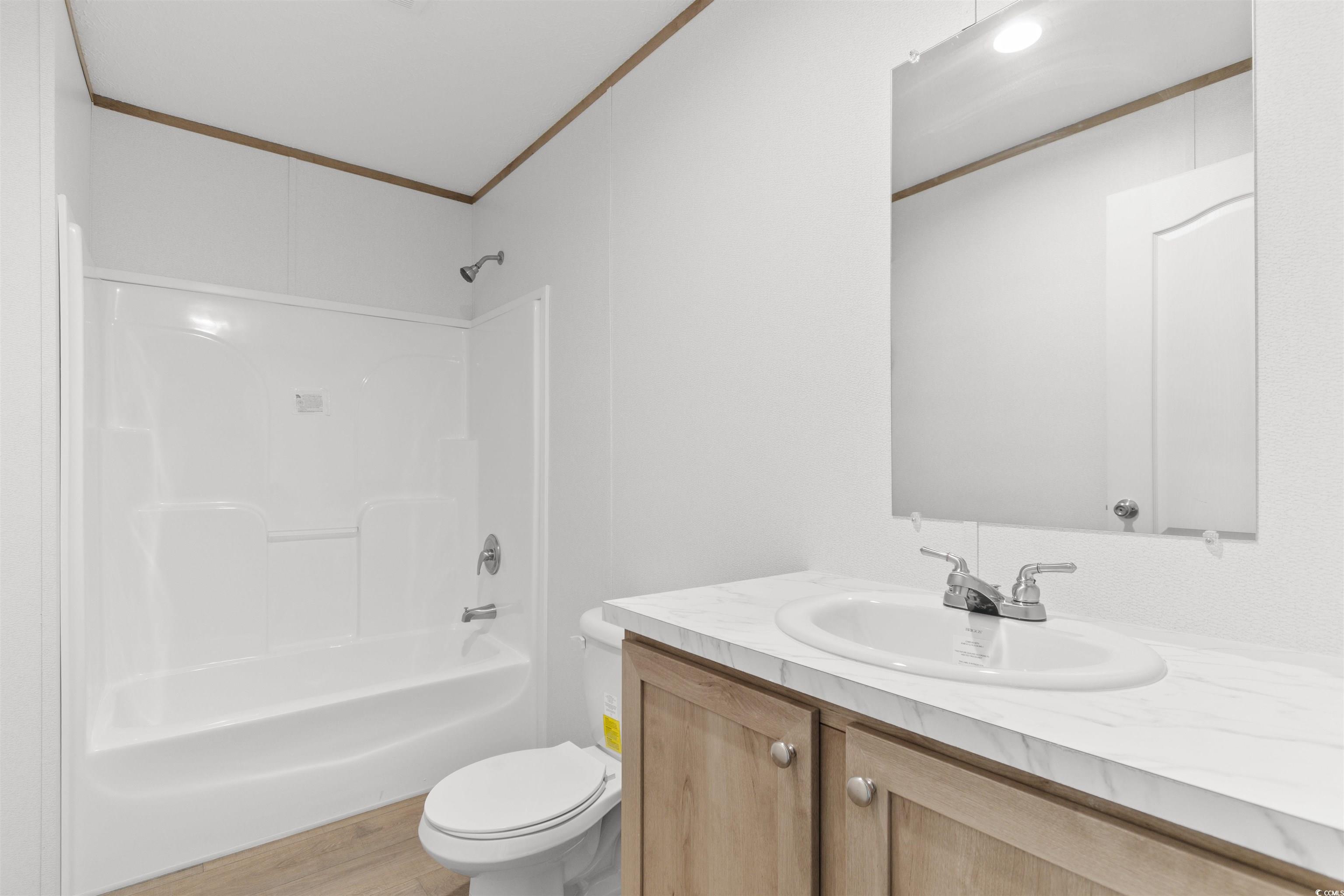 6613 Strickland Road Green Sea, SC 29545 - Photo 20 of 38 Bathroom with shower / bathtub combination, vanity, crown molding, and light wood finished floors