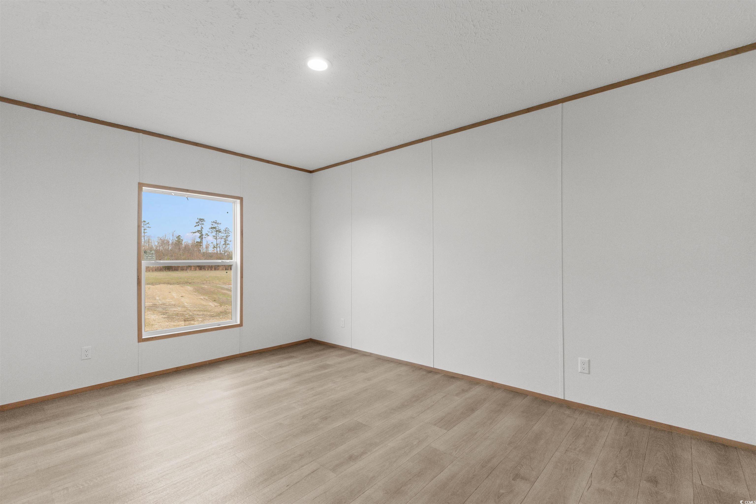6613 Strickland Road Green Sea, SC 29545 - Photo 24 of 38 Spare room featuring light wood-style floors, ornamental molding, and recessed lighting