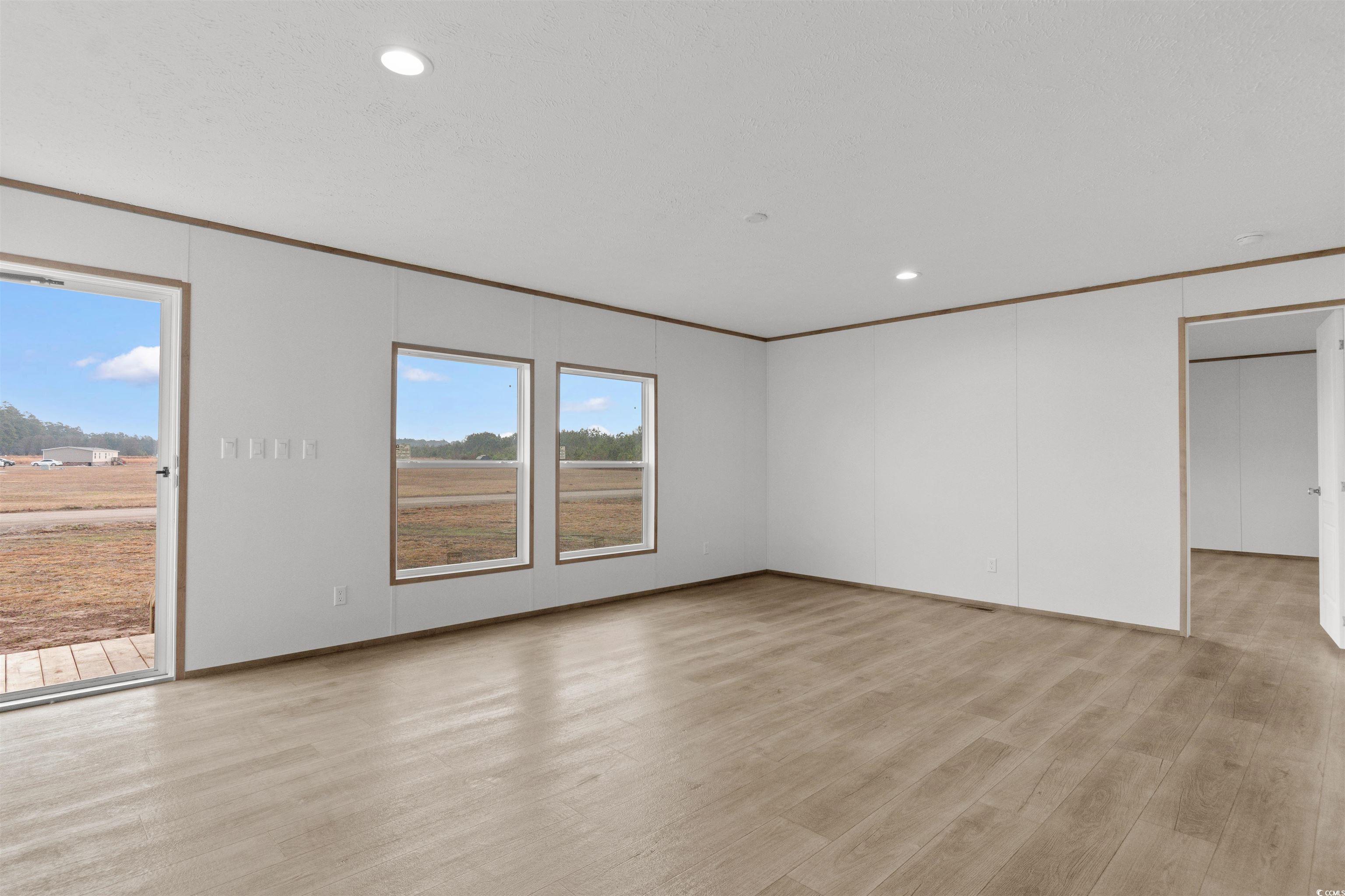 6613 Strickland Road Green Sea, SC 29545 - Photo 3 of 38 Unfurnished room featuring light wood finished floors, recessed lighting, and crown molding