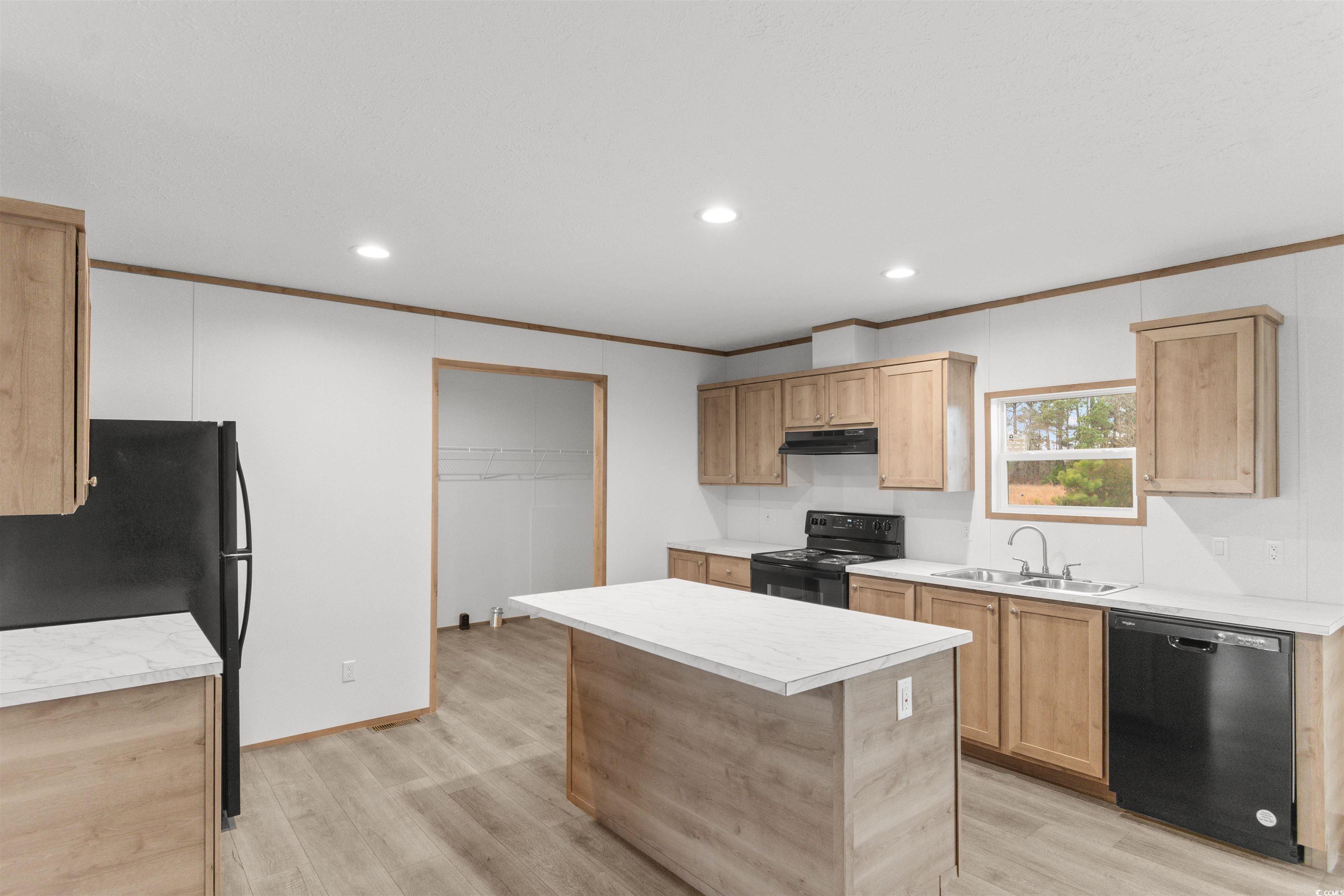 6613 Strickland Road Green Sea, SC 29545 - Photo 8 of 38 Kitchen featuring light countertops, black appliances, recessed lighting, ornamental molding, and light wood-type flooring