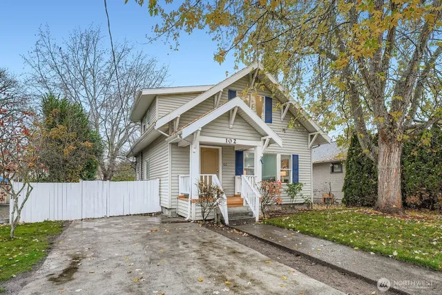 a view of a house with a yard and large trees