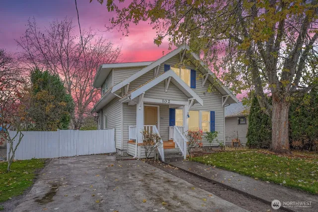 a view of a house with a yard and large trees