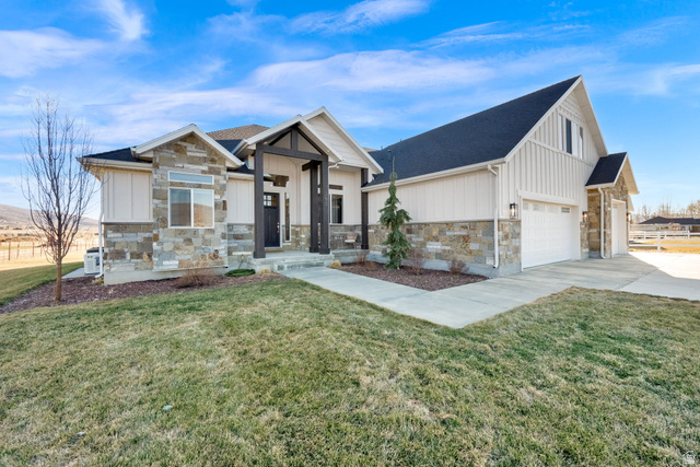 352 East Boulderville Road Oakley, UT 84055 - Photo 41 of 62 Modern farmhouse with stone siding, board and batten siding, a front yard, and concrete driveway
