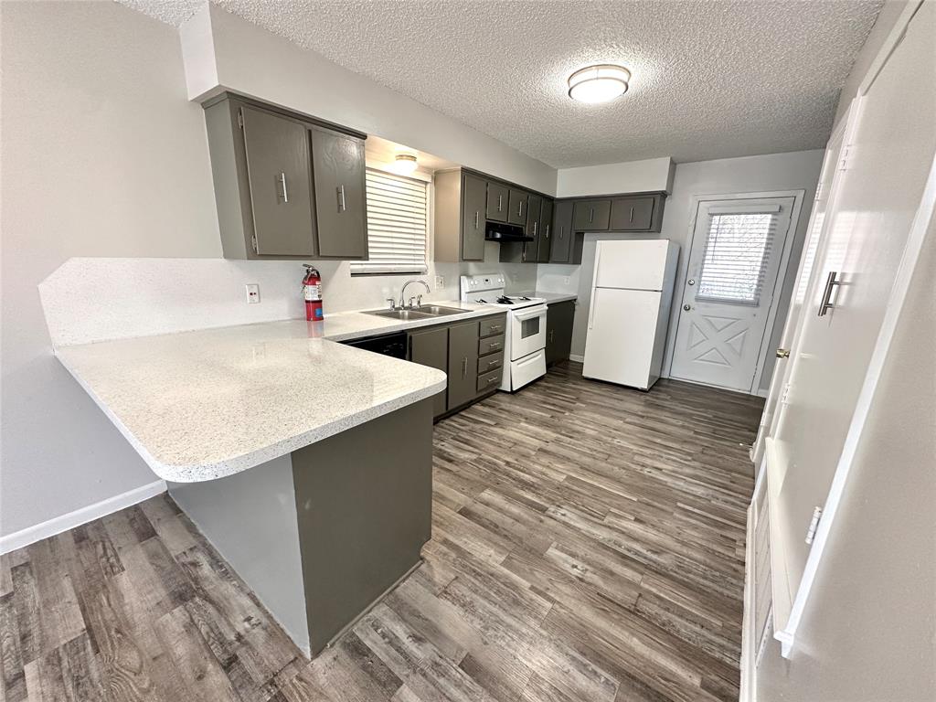 2006 Jane Street, Unit E Longview, TX 75601 - Photo 2 of 10 a kitchen with a sink a refrigerator and cabinets