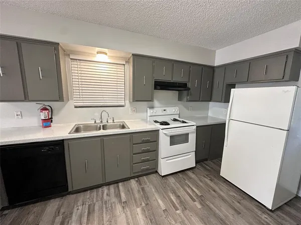 a kitchen with sink a refrigerator and white cabinets