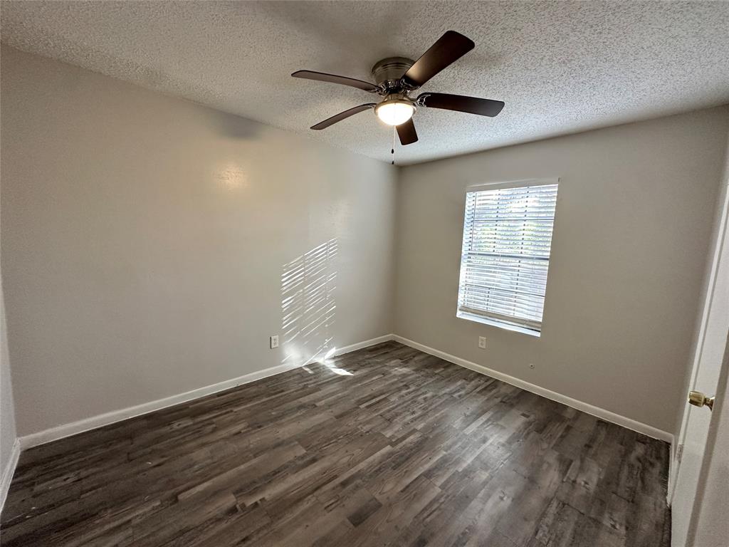 2006 Jane Street, Unit E Longview, TX 75601 - Photo 4 of 10 an empty room with wooden floor fan and windows