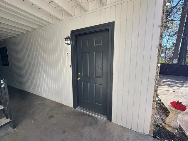 a view of a hallway with a door and wooden floor