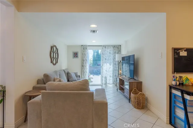 a living room with furniture a flat screen tv and a window