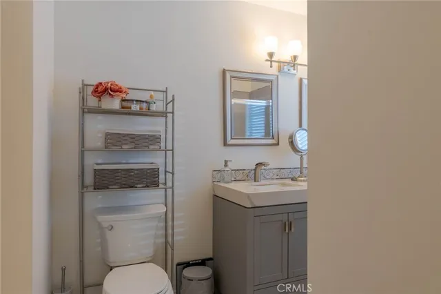 a bathroom with a toilet sink vanity and granite