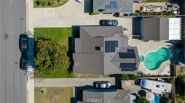 an aerial view of residential houses with outdoor space and parking