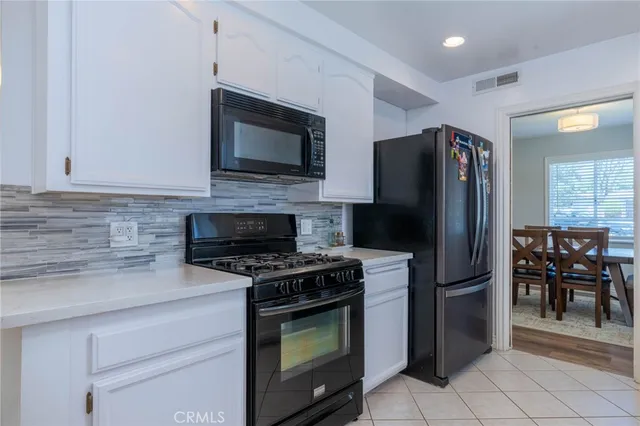 a kitchen with refrigerator a microwave a stove and cabinets
