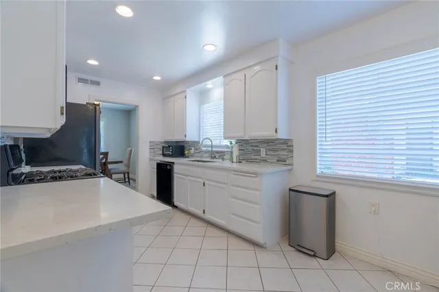 a kitchen with a sink window and cabinets