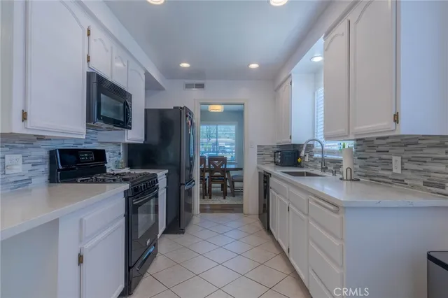 a kitchen with stainless steel appliances granite countertop a stove top oven a sink and a granite counter tops