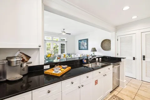 a view of a dining room with furniture a chandelier and a window