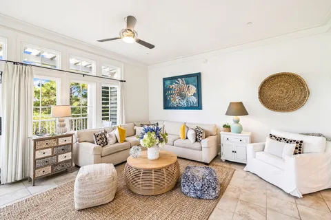a living room with furniture and view of kitchen