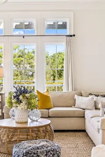 a view of a dining room with furniture a chandelier and a window