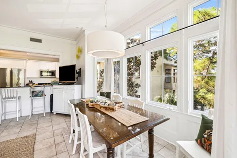 a kitchen with stainless steel appliances granite countertop a stove top oven a sink a refrigerator and white cabinets with wooden floor