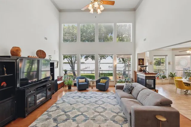 a living room with furniture a flat screen tv and a floor to ceiling window