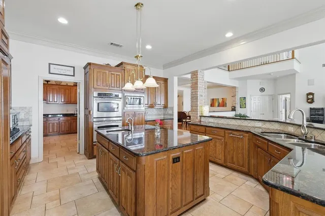 a kitchen with stainless steel appliances granite countertop a sink and a refrigerator