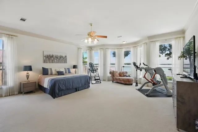 a spacious bedroom with a bed and a chandelier