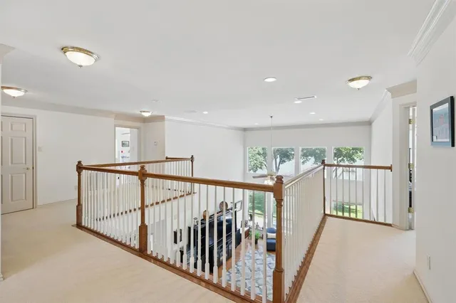 a view of staircase with lots of frames on wall and windows