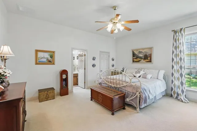 a spacious bedroom with a bed a couch and a chandelier
