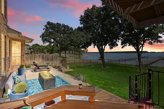 a view of a garden with couches chairs and an umbrella