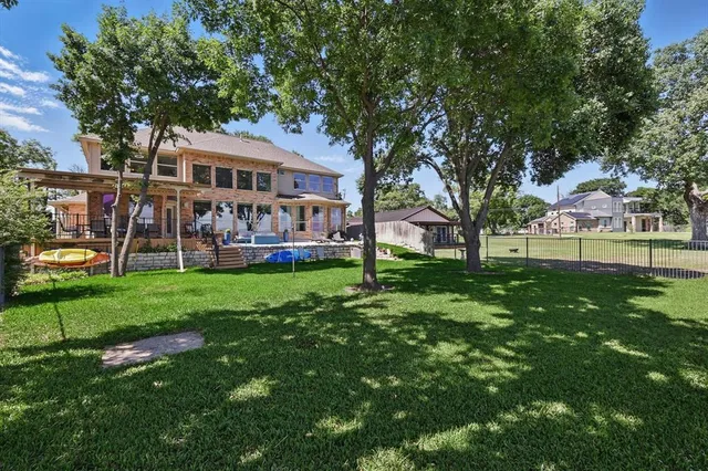 a front view of a house with a garden and trees