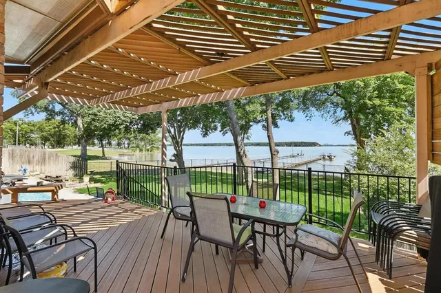 a view of a patio with table and chairs with wooden floor and fence