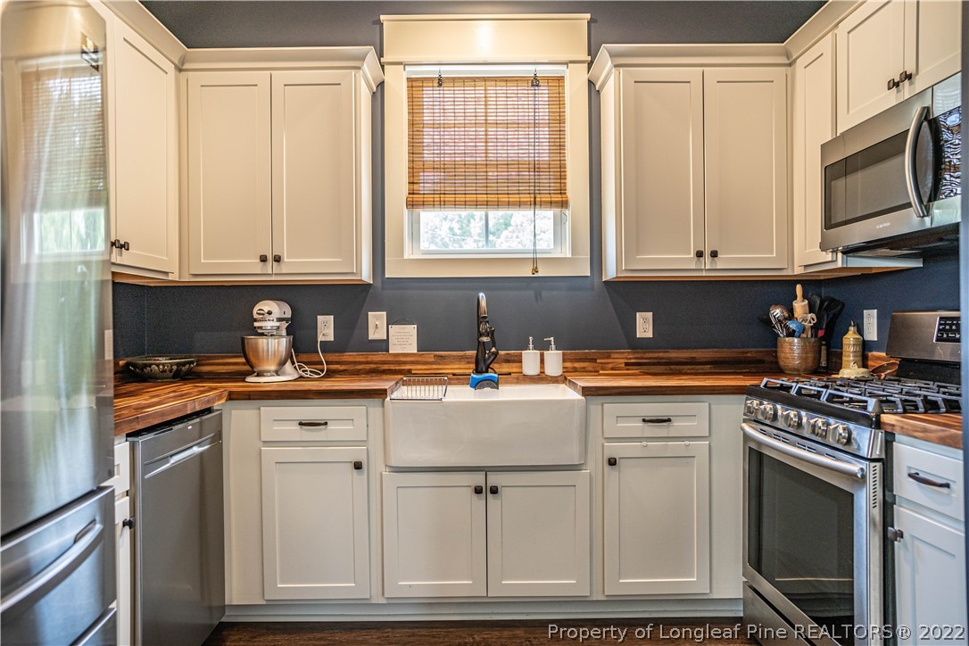 491 Stage Road Carthage, NC 28327 - Photo 18 of 47 a kitchen with stainless steel appliances granite countertop a stove a sink and white cabinets