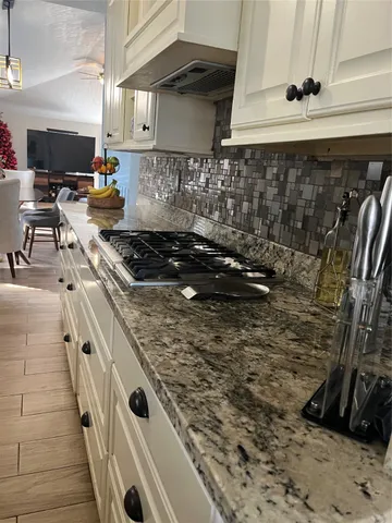 a kitchen with granite countertop a stove and a sink